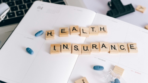 "Health insurance text blocks on a calendar beside a laptop, symbolizing strategic planning for a health insurance campaign